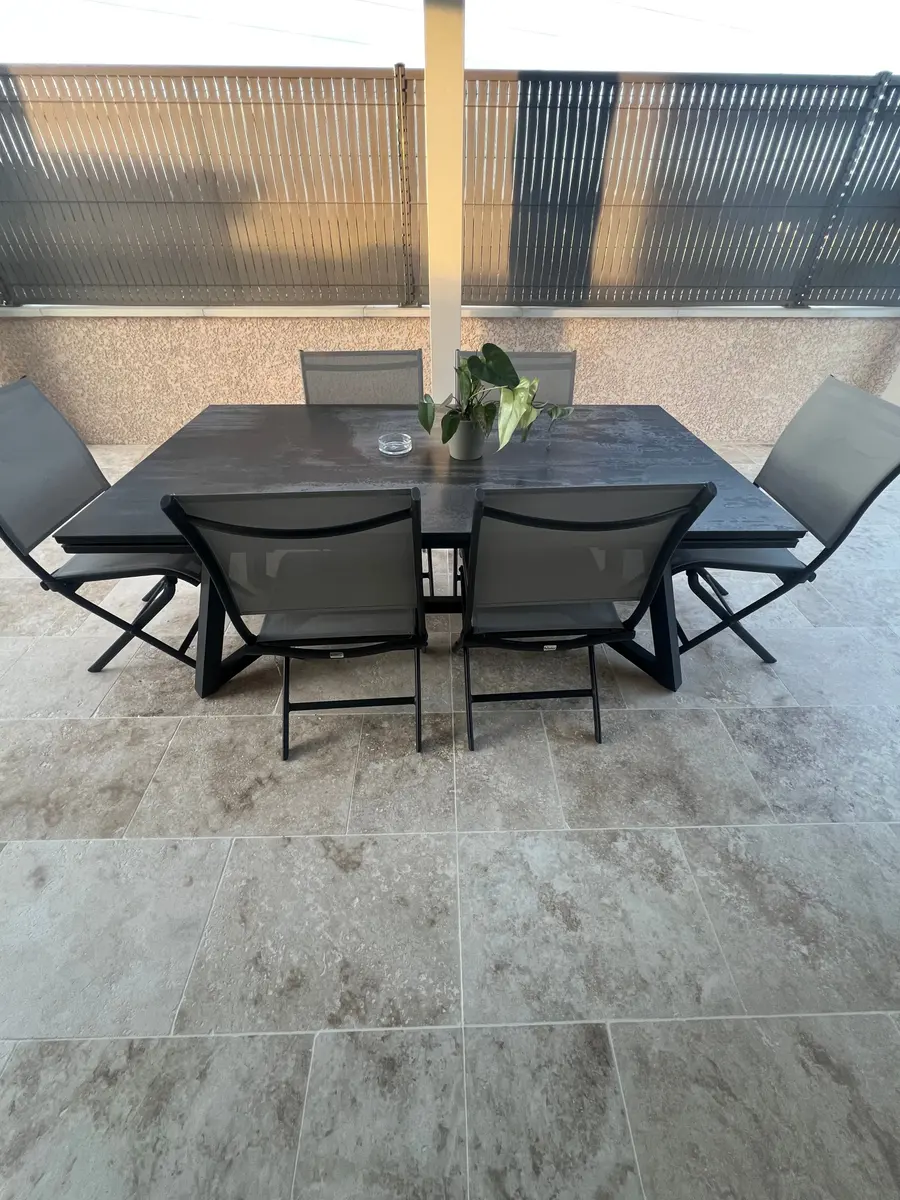 Terrasse carrelée en travertin avec salon de jardin