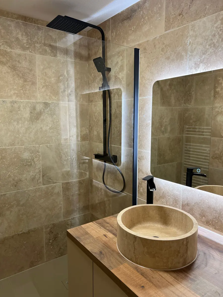 Salle de bain en travertin avec vasque en pierre