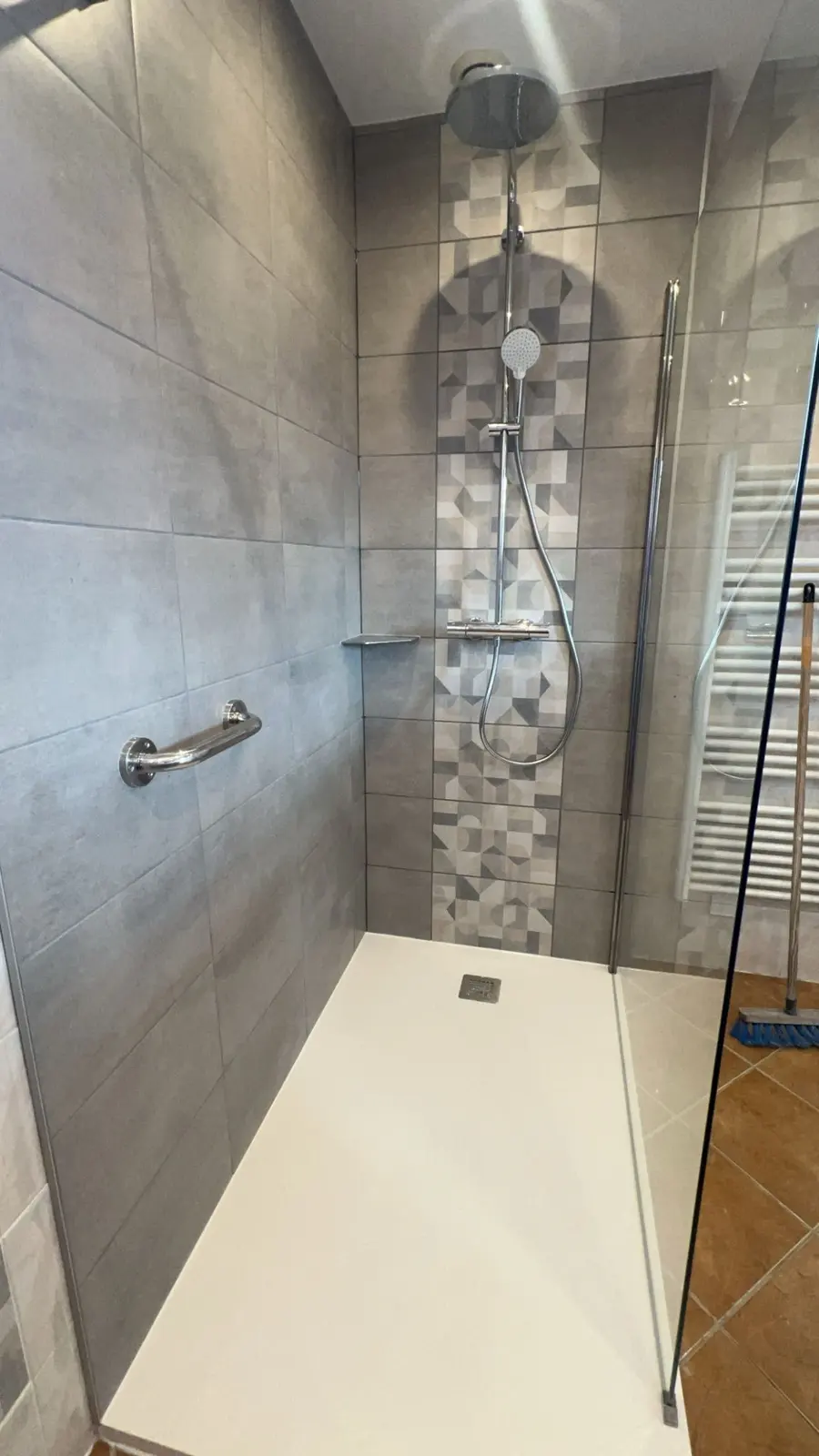Salle de bain après rénovation par LEMY RENOVATION : douche et frise mosaïque